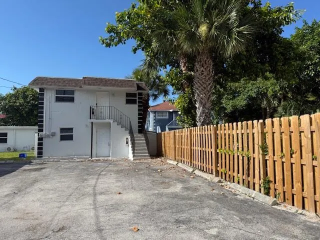 a view of a house with a small yard and a large tree
