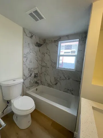 a bathroom with a bathtub and toilet