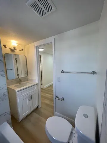 a bathroom with a granite countertop sink toilet and shower