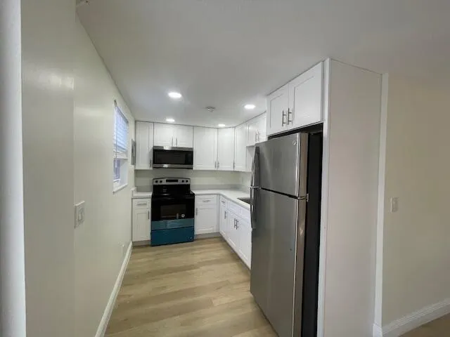 a view of a room with wooden floor and a window