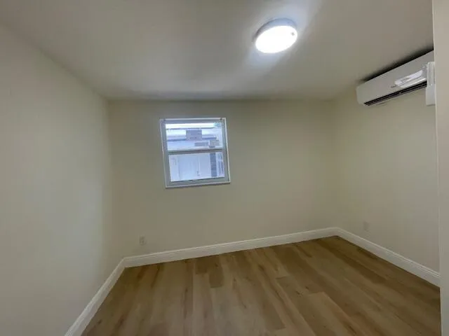 a view of a room with wooden floor and window