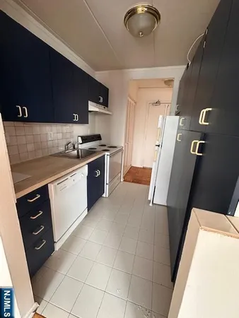 a kitchen with a sink a stove top oven and cabinets