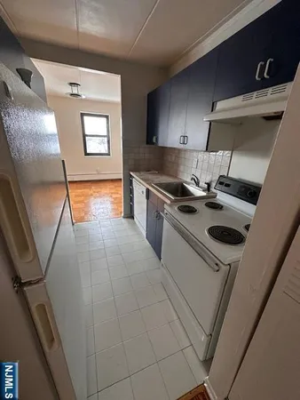 a kitchen with a sink a stove and cabinets