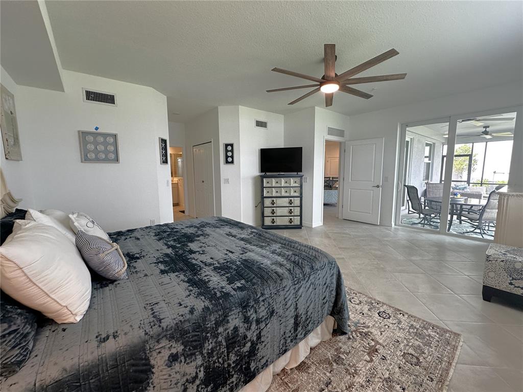 14192 Poppy Fld Loop, Unit 5011 Punta Gorda, FL 33955 - Photo 11 of 48 a bedroom with a large bed and a chandelier