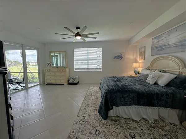 a bedroom with a large bed and a chandelier