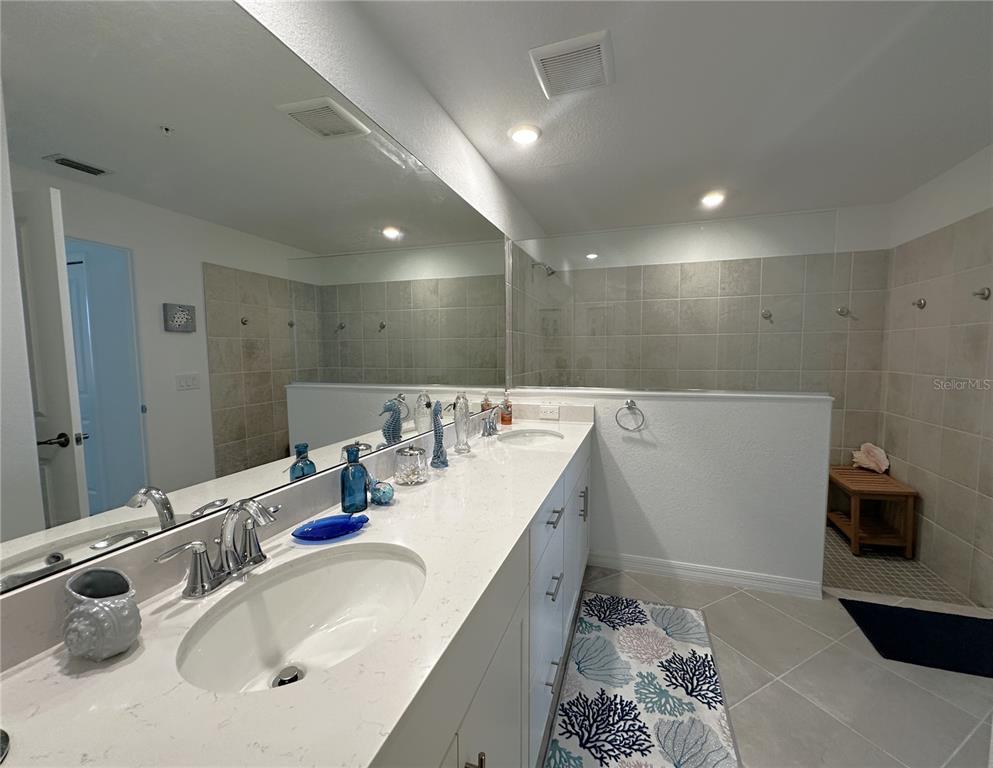 14192 Poppy Fld Loop, Unit 5011 Punta Gorda, FL 33955 - Photo 13 of 48 a bathroom with a double vanity sink and a mirror