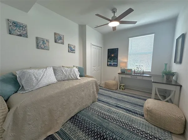 a living room with furniture a couch and a ceiling fan