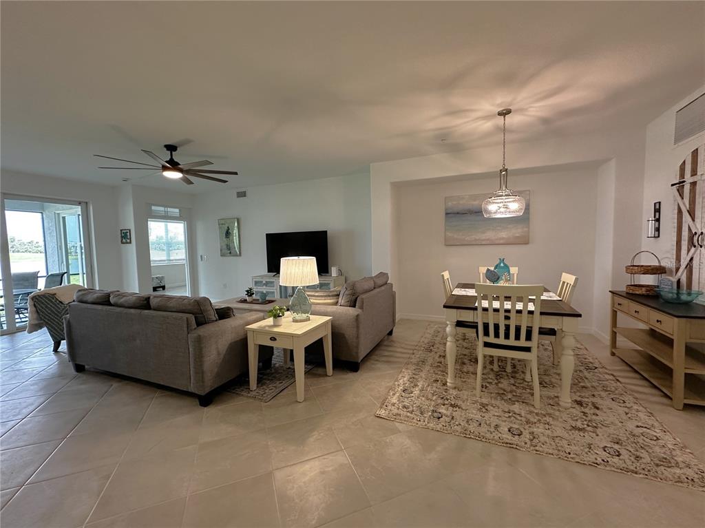 14192 Poppy Fld Loop, Unit 5011 Punta Gorda, FL 33955 - Photo 2 of 48 a living room with furniture a chandelier and a dining table