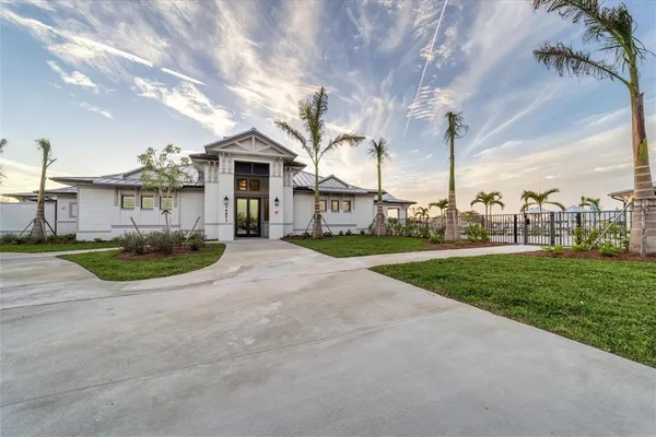 a view of a house with a yard and palm trees