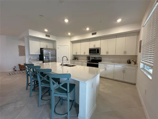 a kitchen with a table a sink stainless steel appliances and cabinets