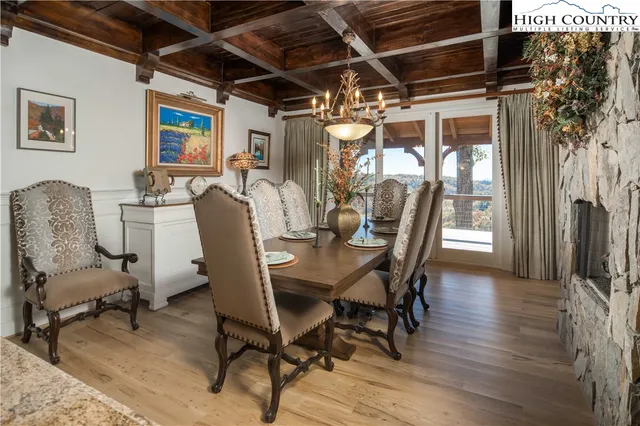 a dining room with furniture a floor to ceiling window and wooden floor
