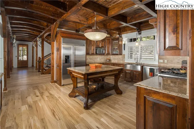 a kitchen with stainless steel appliances granite countertop a stove a sink and a wooden floors