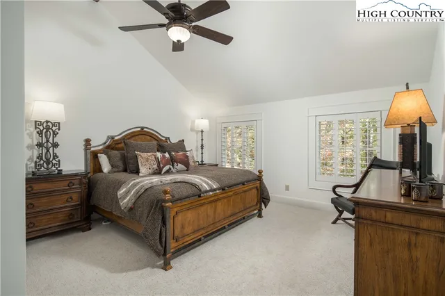 a bedroom with a bed and a flat tv screen on the dresser