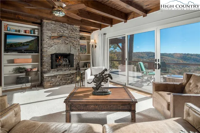 a living room with fireplace furniture and a floor to ceiling window
