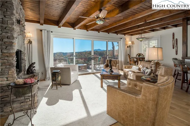 a living room with fireplace furniture and a floor to ceiling window