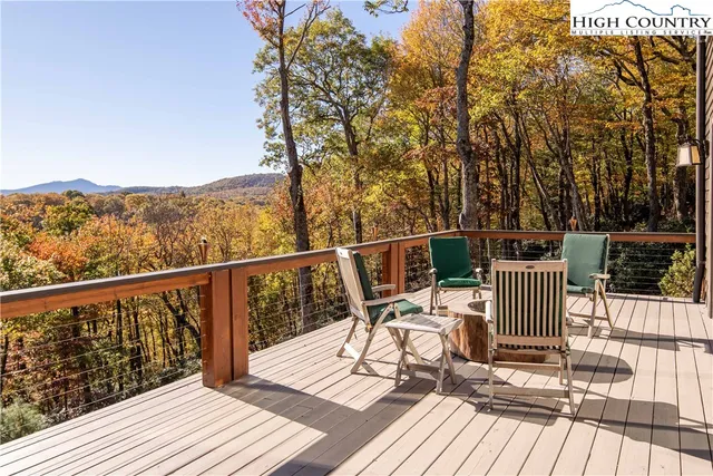 a view of a balcony with wooden floor and outdoor seating