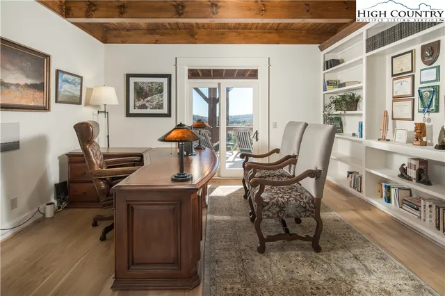 a view of a workspace with furniture and a window