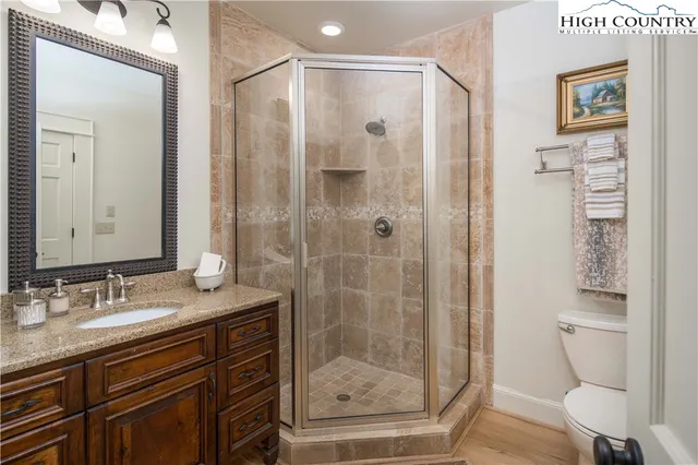 a bathroom with a granite countertop sink toilet and shower