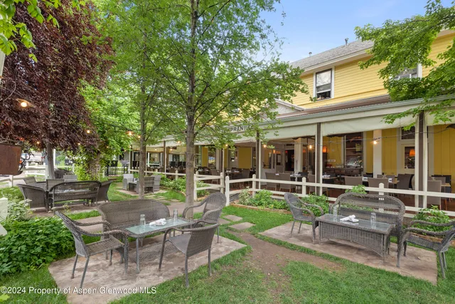 a view of a house with backyard sitting area and garden