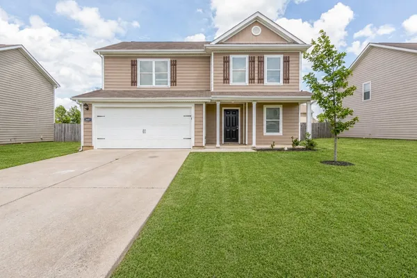 a front view of a house with a yard and garage