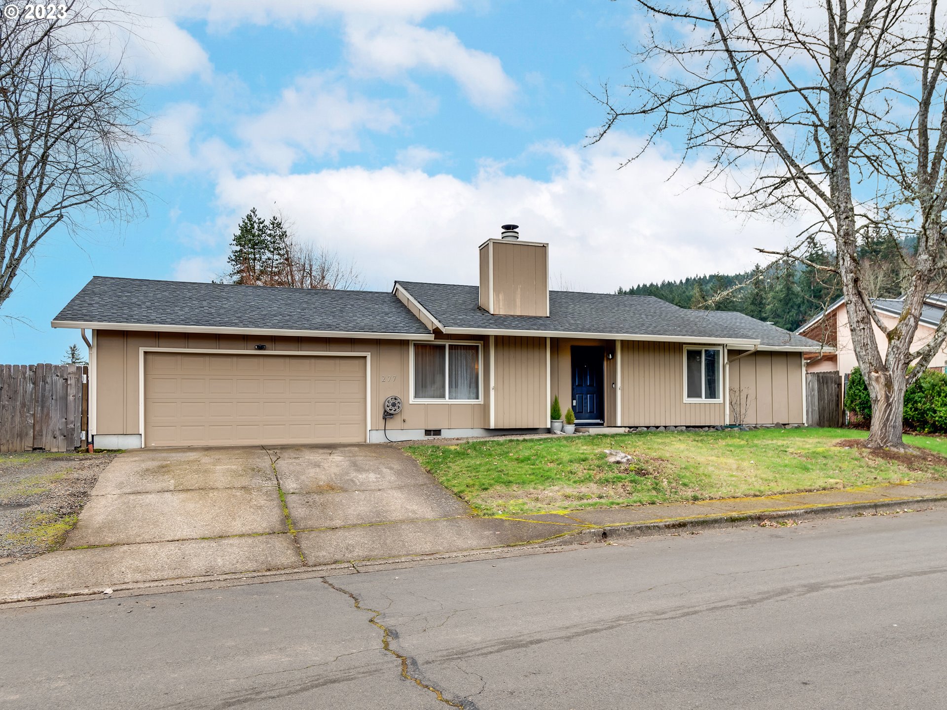 277 South 70th Place Springfield, OR 97478 - Photo 1 of 26 a front view of a house with a yard and garage