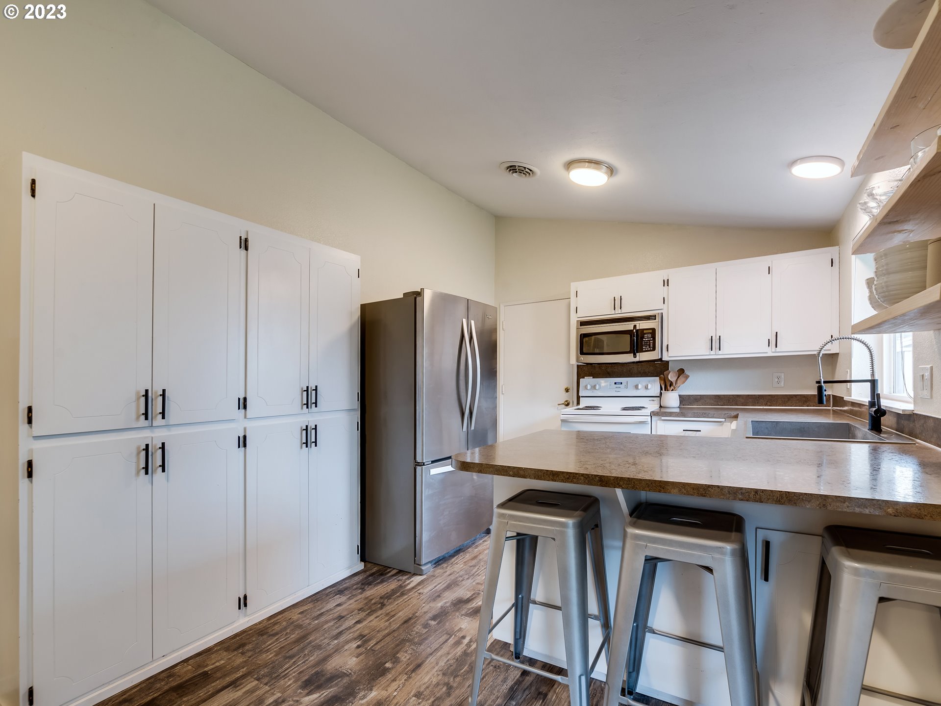 277 South 70th Place Springfield, OR 97478 - Photo 6 of 26 a kitchen with kitchen island granite countertop cabinets and refrigerator