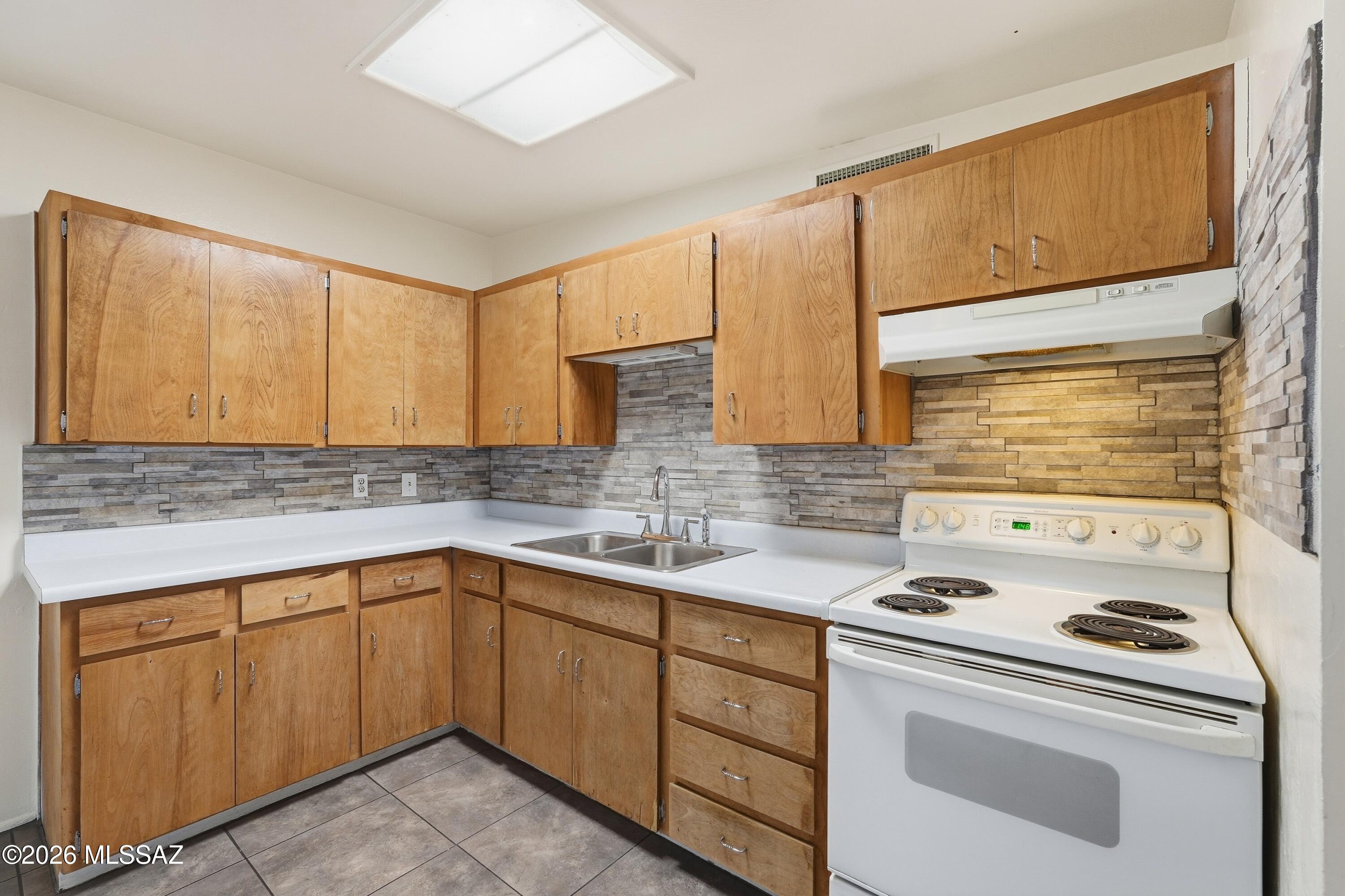 1808 West Caravelle Road Tucson, AZ 85713 - Photo 15 of 38 a kitchen with a sink stove and cabinets