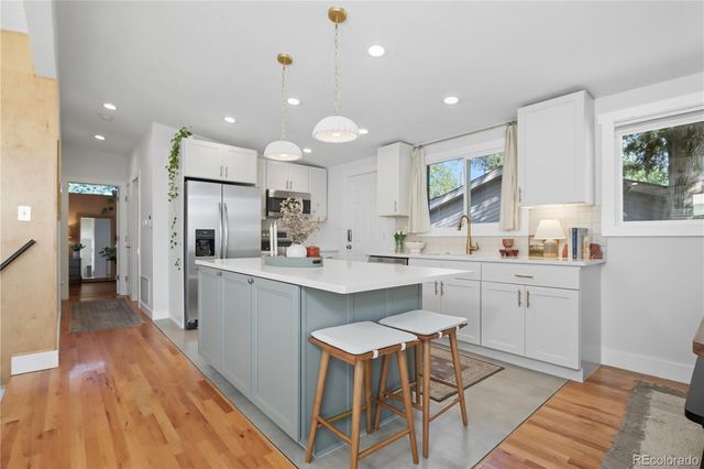 a kitchen with white cabinets and refrigerator