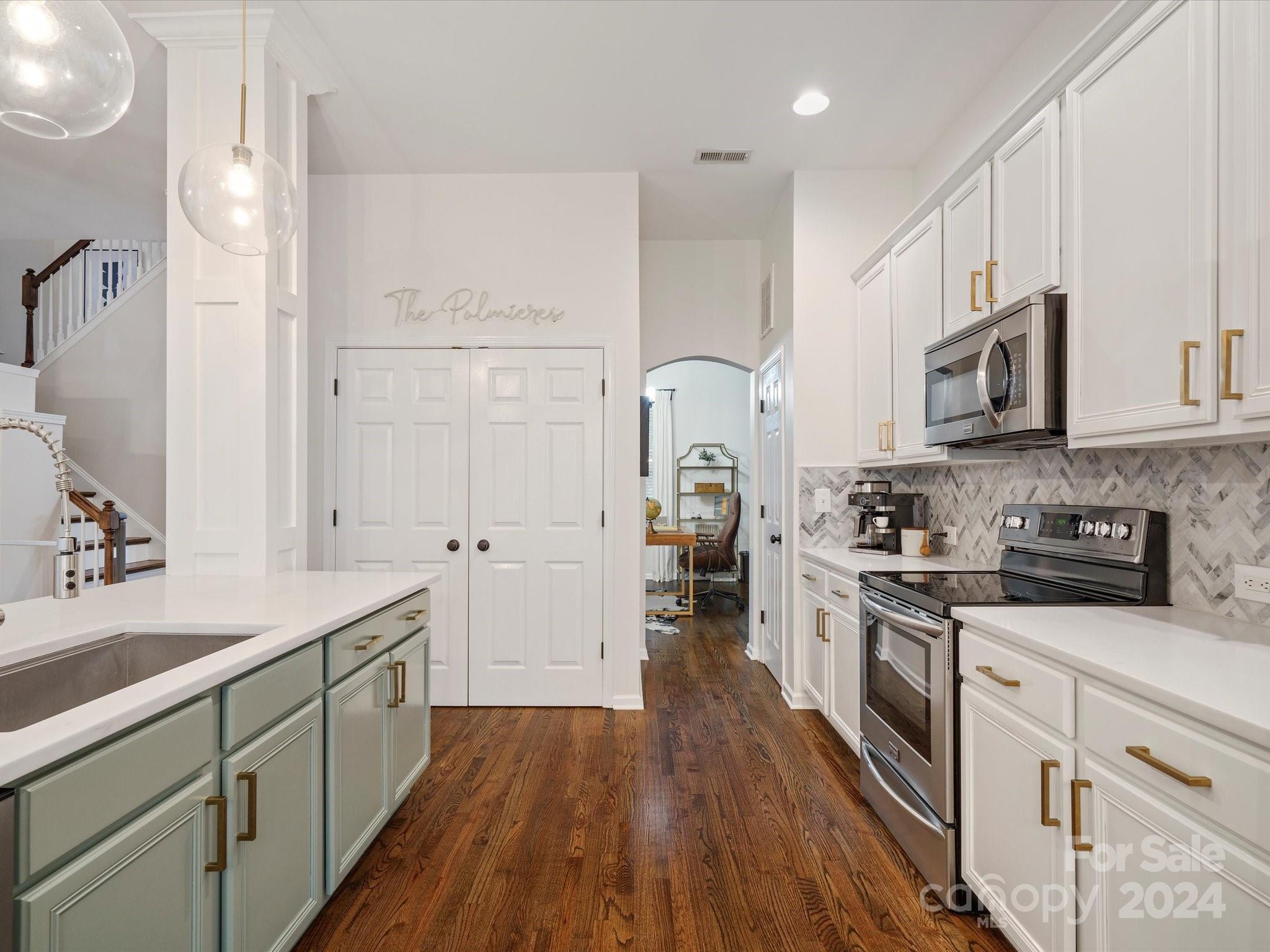 432 Third Baxter Street Fort Mill, SC 29708 - Photo 24 of 48 a kitchen with stainless steel appliances a stove top oven a sink a refrigerator white cabinets and wooden floor