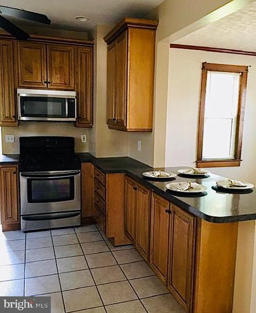 218 Chestnut Street Audubon, NJ 08106 - Photo 5 of 11 a kitchen with stainless steel appliances granite countertop a stove a sink and a microwave