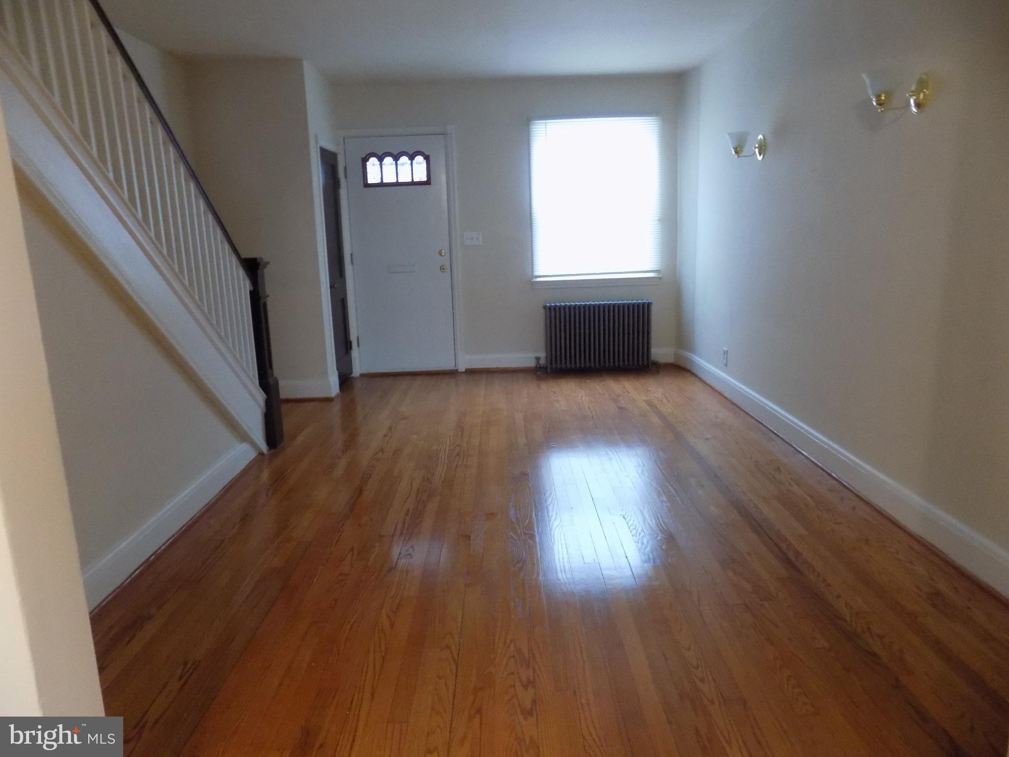 3925 Colborne Road Baltimore, MD 21229 - Photo 4 of 13 an empty room with wooden floor and windows
