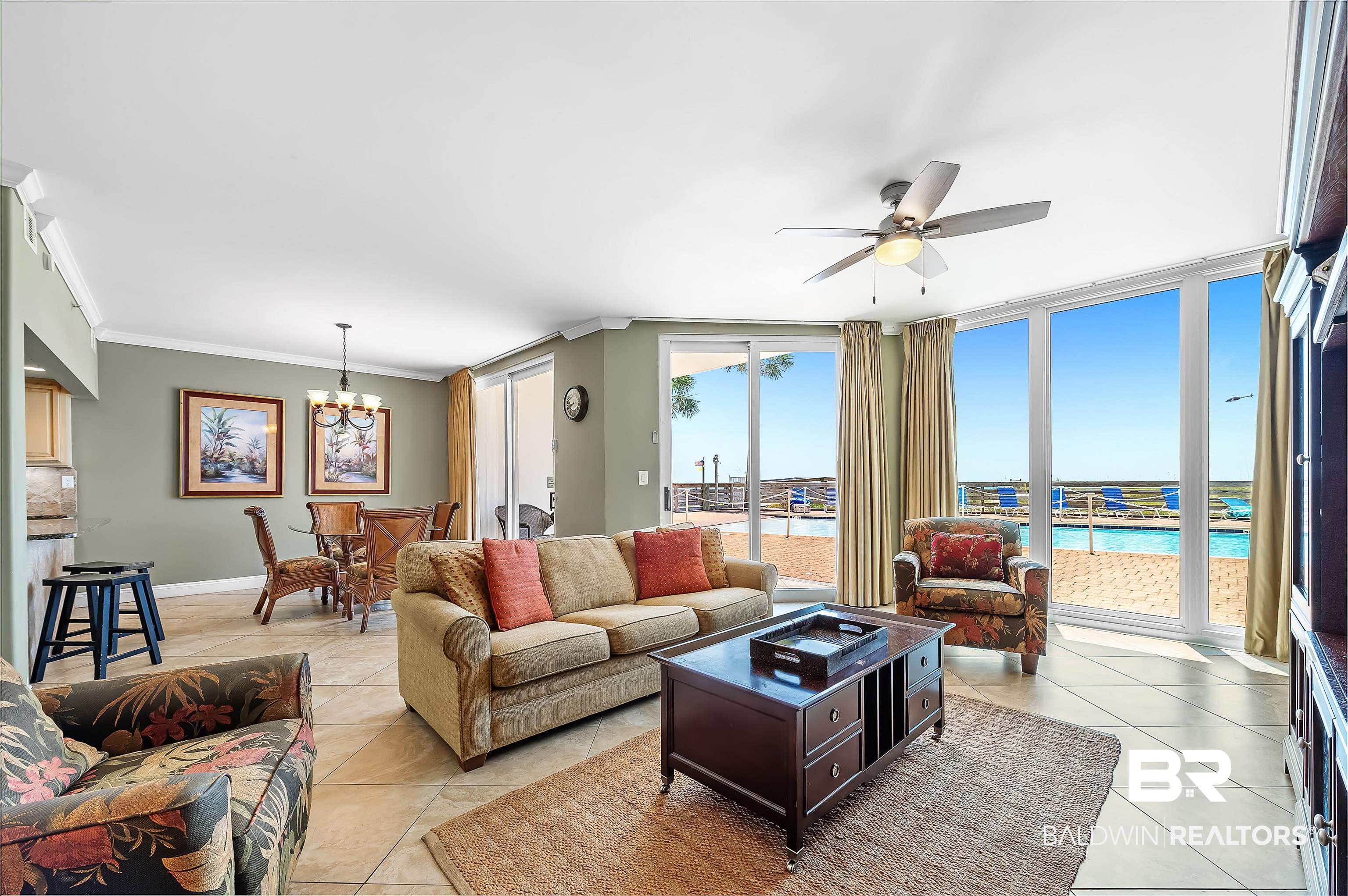 16287 Perdido Key Drive, Unit 105 Pensacola, FL 32507 - Photo 9 of 66 Open-concept living space featuring expansive glass doors, tile flooring, a ceiling fan, and crown molding