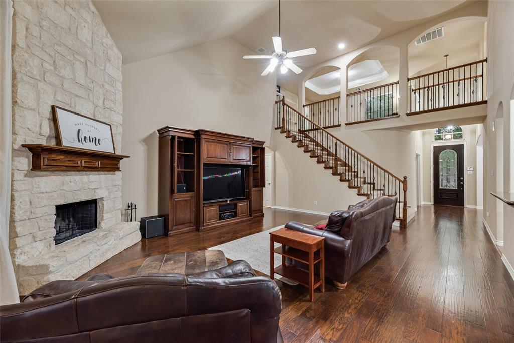11920 Vienna Apple Road Fort Worth, TX 76244 - Photo 13 of 40 Expansive living room with hardwood floors, wood burning fireplace with gas starter, soaring vaulted ceilings and views of the upstairs game room at 11920 Vienna Apple in Villages of Woodland Springs community in North Fort Worth