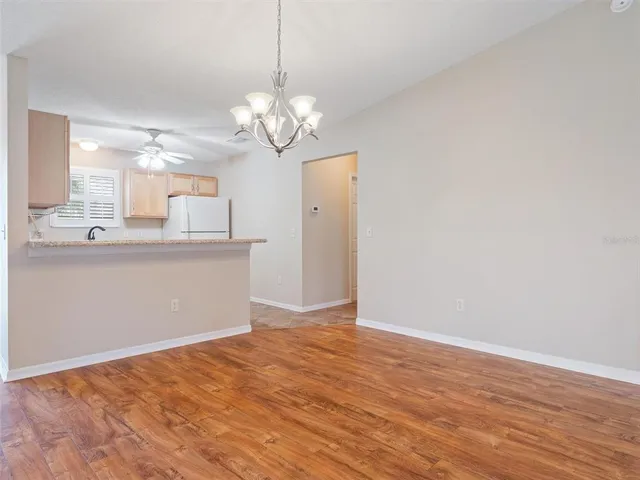 a view of a kitchen with stainless steel appliances granite countertop a refrigerator a sink dishwasher a stove and white walls