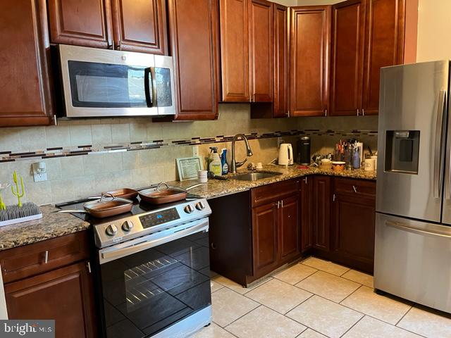 310 Earlham Terrace Philadelphia, PA 19144 - Photo 3 of 9 a kitchen with stainless steel appliances granite countertop a stove a refrigerator and a microwave
