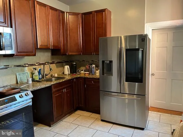 a kitchen with stainless steel appliances granite countertop a refrigerator stove a sink and dishwasher