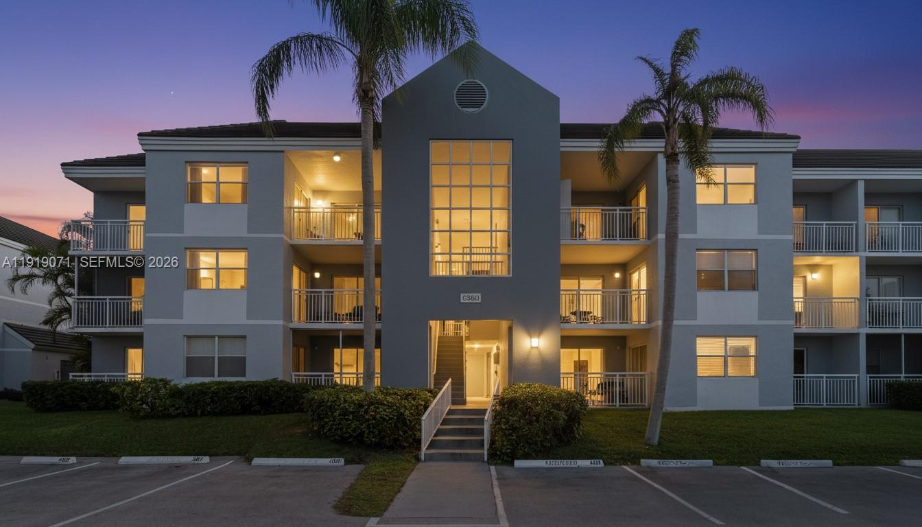 8560 Southwest 212th Street, Unit 308 Cutler Bay, FL 33189 - Photo 1 of 21 a front view of a residential apartment building with a yard