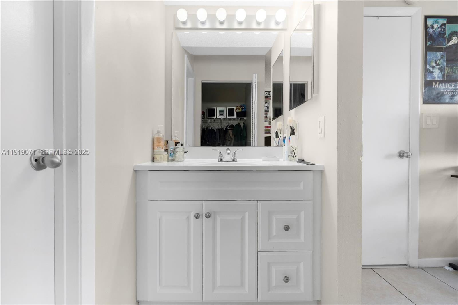 8560 Southwest 212th Street, Unit 308 Cutler Bay, FL 33189 - Photo 11 of 26 a bathroom with a sink vanity and a mirror