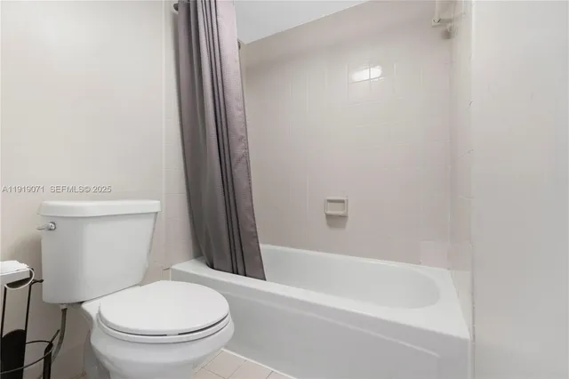 a white toilet sitting next to a bathtub