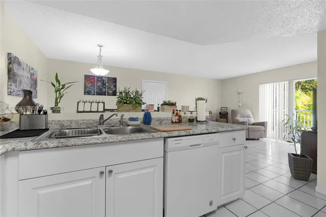 a kitchen with white cabinets and sink