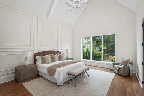 a bedroom with furniture and a large window