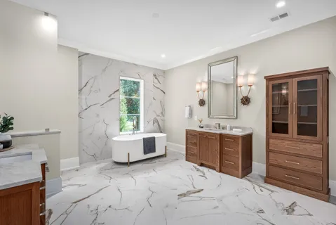 a spacious bathroom with a tub sink and mirror