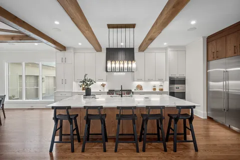 a kitchen with a dining table chairs refrigerator and cabinets