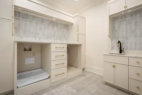 a kitchen with white cabinets and sink