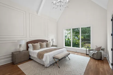 a bedroom with furniture and a large window