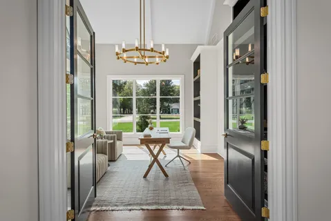 a dining room with furniture a chandelier and wooden floor