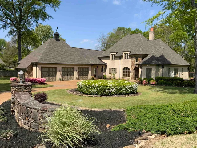 a front view of a house with yard and green space