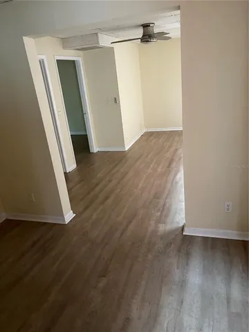 an empty room with wooden floor and entrance