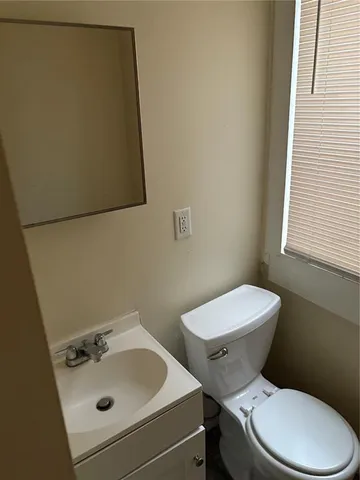 a white toilet sitting next to a bathroom sink