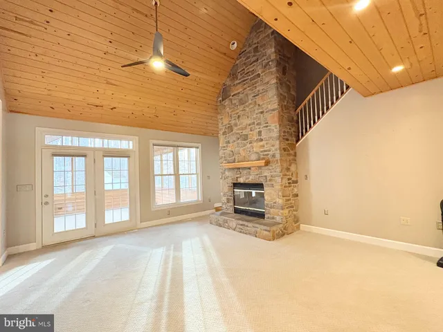 a large kitchen with kitchen island granite countertop a stove a sink and white cabinets with wooden floors